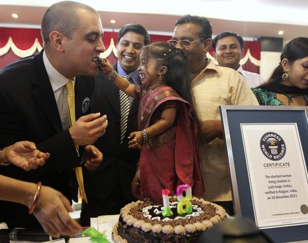 Amge, the world's shortest living woman offers a cake to the Guinness World Records adjudicator Molloy in Nagpur